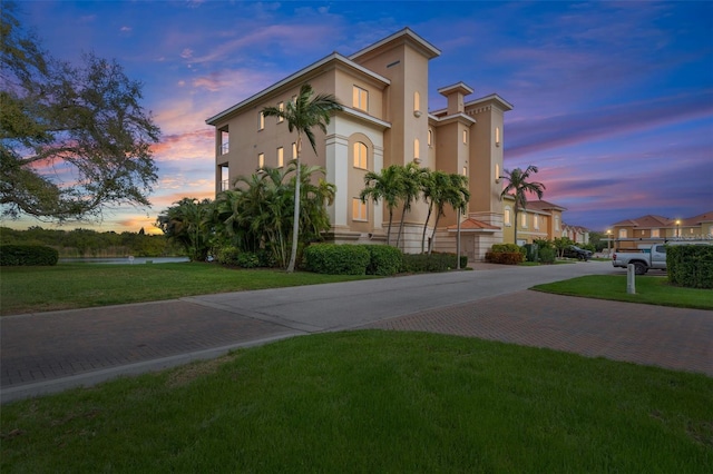 43 Bayview Ct S # A, Saint Petersburg, FL 33711 - view of front of house featuring stucco siding, a yard, and a water view
