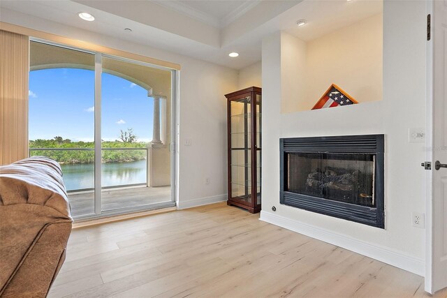 43 Bayview Ct S # A, Saint Petersburg, FL 33711 - unfurnished living room with ornamental molding, recessed lighting, light wood-type flooring, baseboards, and a fireplace