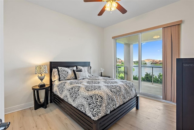 43 Bayview Ct S # A, Saint Petersburg, FL 33711 - bedroom featuring access to outside, light wood-style floors, a water view, and baseboards
