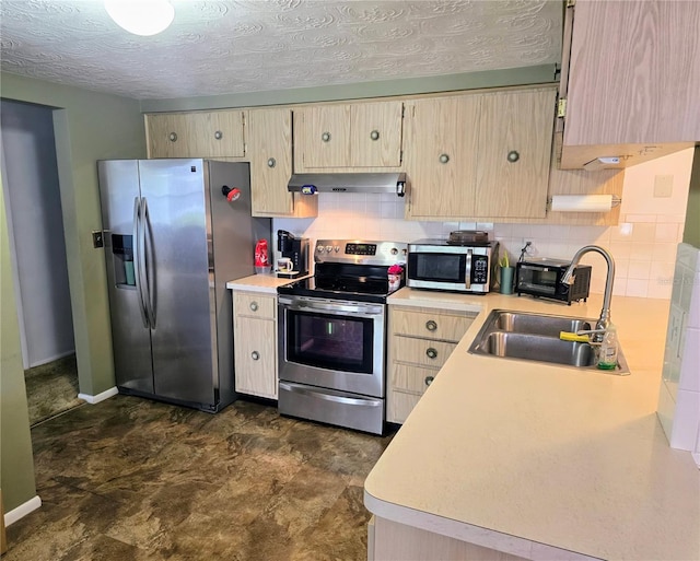 kitchen with appliances with stainless steel finishes, light brown cabinets, a textured ceiling, and sink