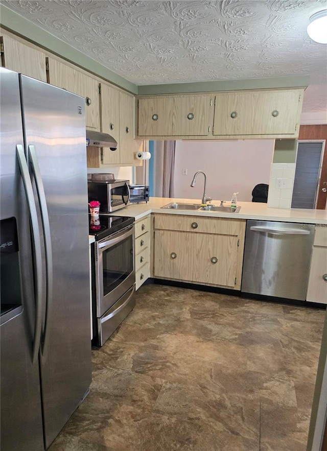 kitchen featuring light brown cabinetry, a textured ceiling, stainless steel appliances, and sink