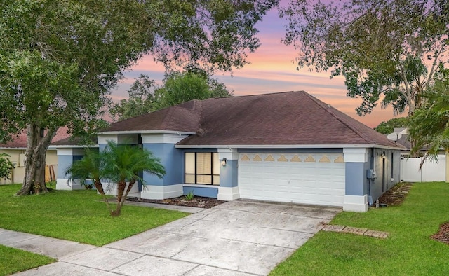 view of front facade with a garage and a lawn