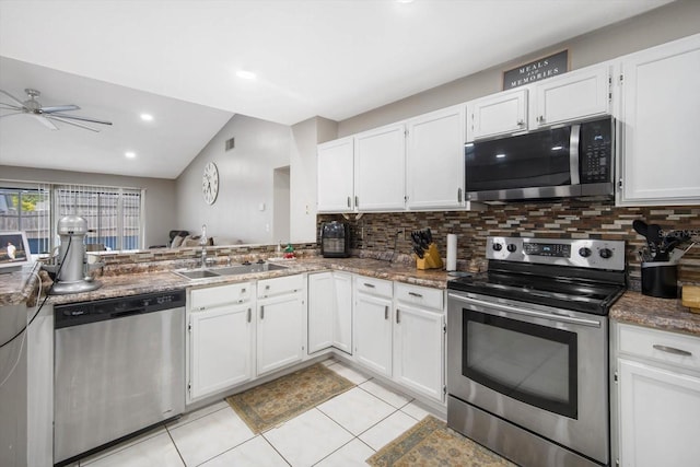 kitchen with white cabinets, lofted ceiling, appliances with stainless steel finishes, and sink