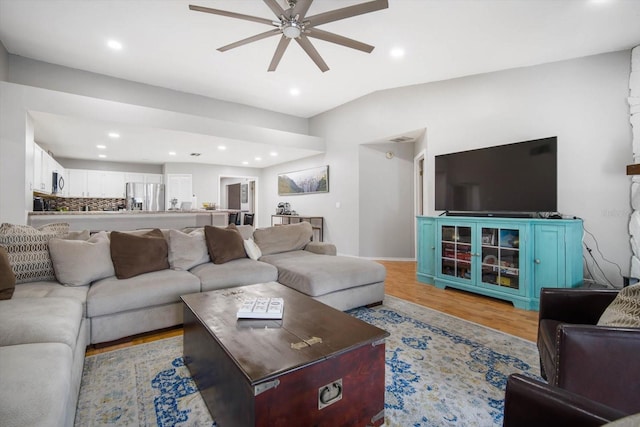 living room with ceiling fan and light hardwood / wood-style flooring