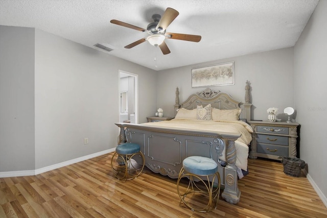 bedroom featuring a textured ceiling, ceiling fan, and light hardwood / wood-style flooring