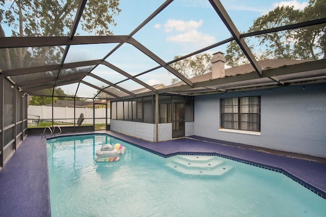 view of swimming pool featuring a patio and a lanai