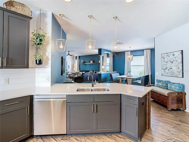 kitchen with gray cabinetry, sink, stainless steel dishwasher, ceiling fan, and kitchen peninsula