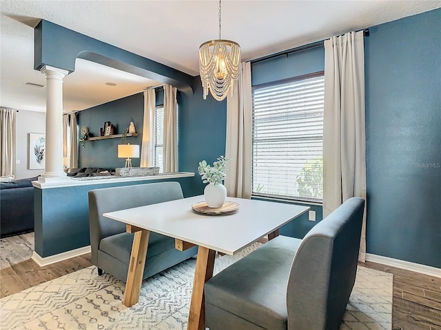 dining space with plenty of natural light, light wood-type flooring, and an inviting chandelier