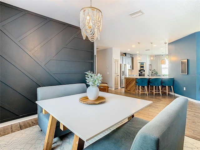 dining area featuring light hardwood / wood-style floors and an inviting chandelier