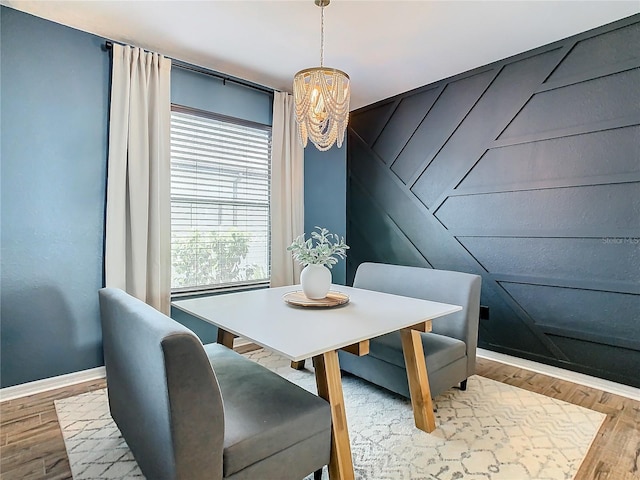 dining space with light wood-type flooring and an inviting chandelier