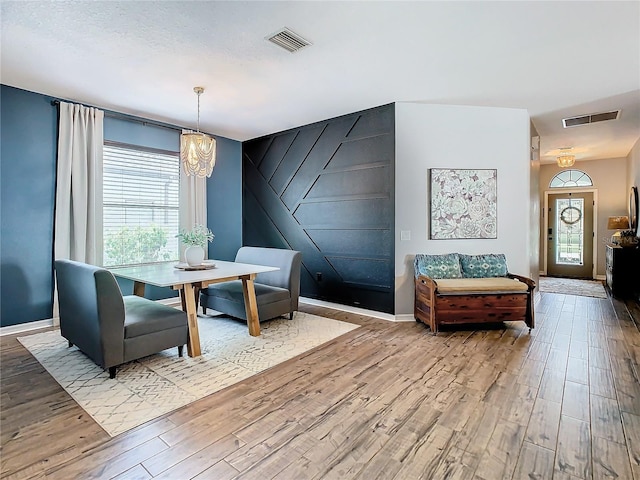 dining space featuring hardwood / wood-style floors and an inviting chandelier