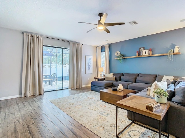 living room with ceiling fan and light hardwood / wood-style flooring