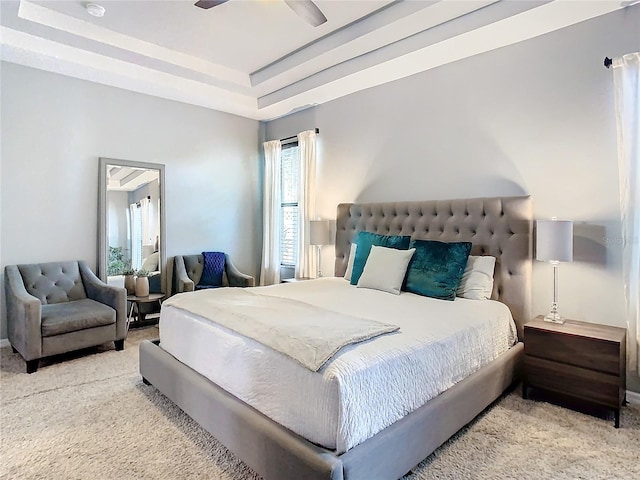 bedroom with ceiling fan, a raised ceiling, and light colored carpet