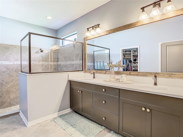 bathroom with tile patterned floors, vanity, and tiled shower