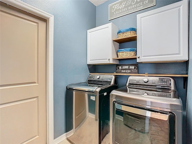 clothes washing area with cabinets and separate washer and dryer