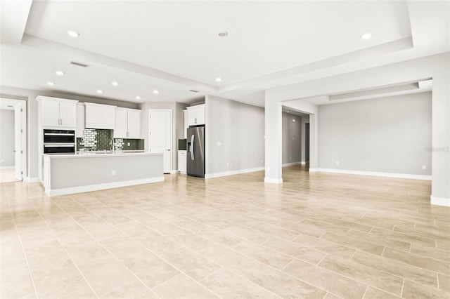 unfurnished living room featuring a tray ceiling