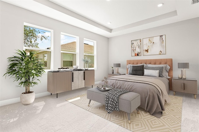 bedroom featuring light colored carpet and a tray ceiling