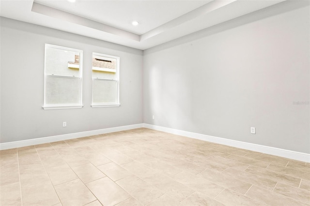 spare room with a tray ceiling