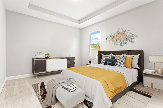 carpeted bedroom featuring a raised ceiling