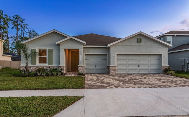 23176 Pachino Way, Lutz, FL 33549 - view of front of home featuring stone siding, decorative driveway, a garage, stucco siding, and a front lawn