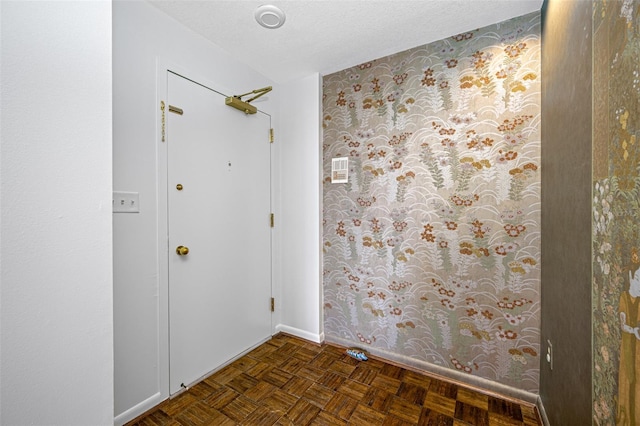 empty room with a textured ceiling and dark parquet flooring