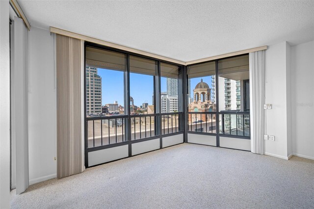 unfurnished room featuring a textured ceiling and light colored carpet