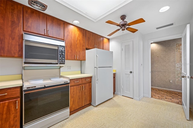 kitchen featuring light countertops, visible vents, a ceiling fan, and white appliances