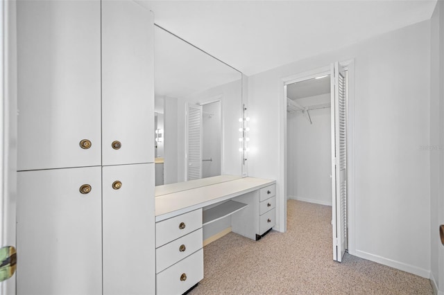 walk in closet featuring light carpet