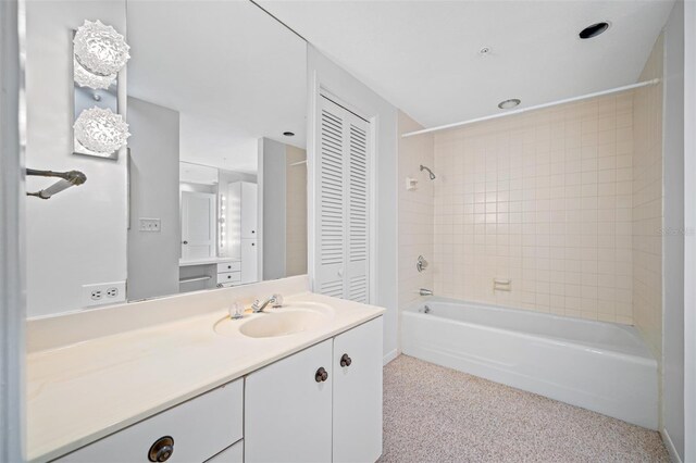 bathroom featuring tiled shower / bath combo and vanity