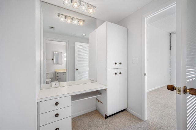 bathroom with toilet, vanity, baseboards, and visible vents