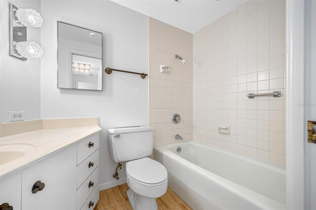 full bathroom with tiled shower / bath combo, vanity, toilet, and hardwood / wood-style floors