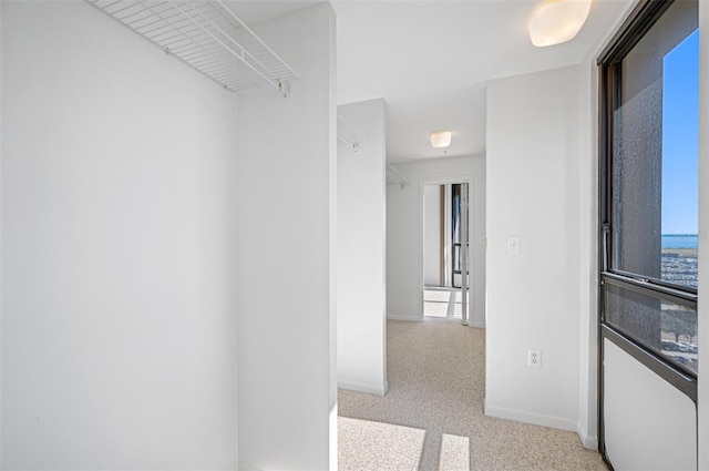 hall featuring baseboards and carpet