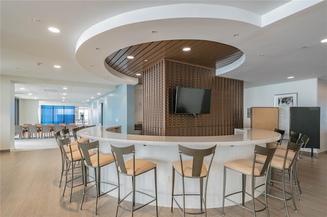 kitchen with a breakfast bar area and light hardwood / wood-style flooring