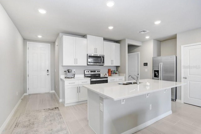 kitchen with white cabinets, an island with sink, appliances with stainless steel finishes, and sink