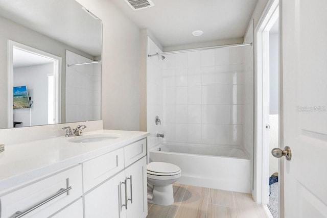 full bathroom featuring tiled shower / bath combo, vanity, and toilet