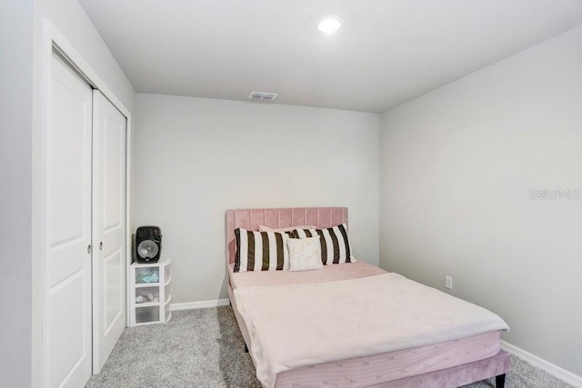 bedroom featuring light colored carpet and a closet