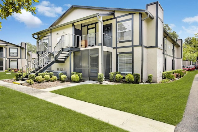 view of front facade with a balcony and a front yard