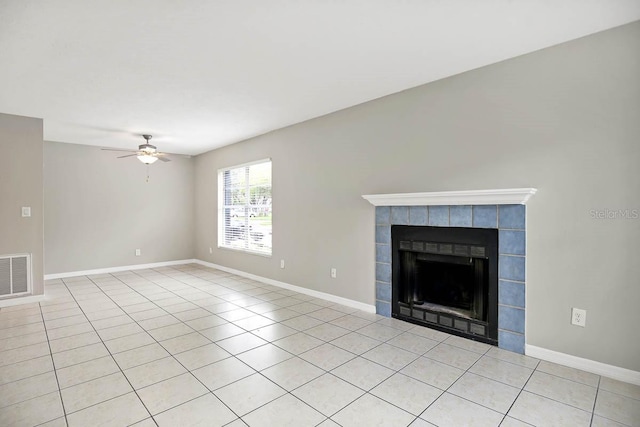 unfurnished living room featuring a fireplace, light tile patterned flooring, and ceiling fan