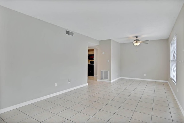 tiled spare room featuring ceiling fan