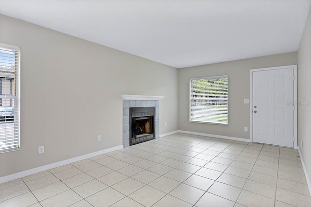 unfurnished living room with a tiled fireplace and light tile patterned floors