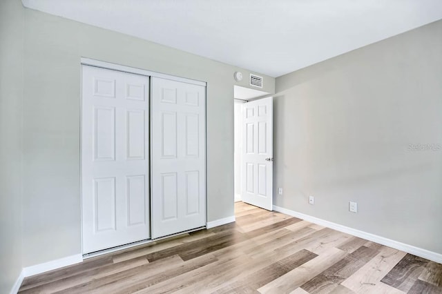 unfurnished bedroom featuring light wood-type flooring and a closet