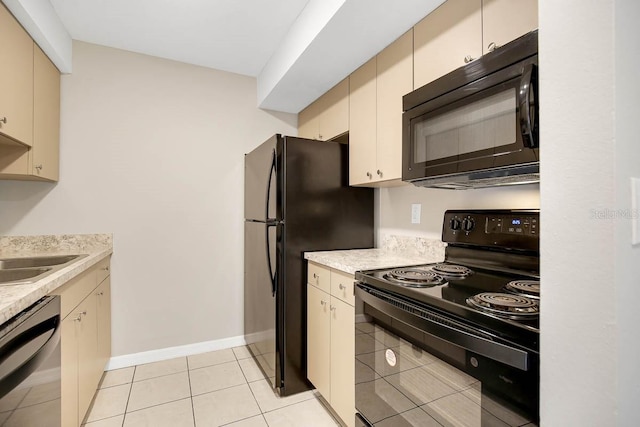 kitchen with cream cabinets, sink, light tile patterned flooring, and black appliances