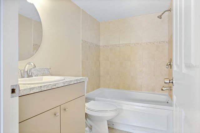 full bathroom with tiled shower / bath, vanity, and toilet