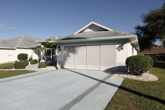 single story home featuring a garage and a front lawn