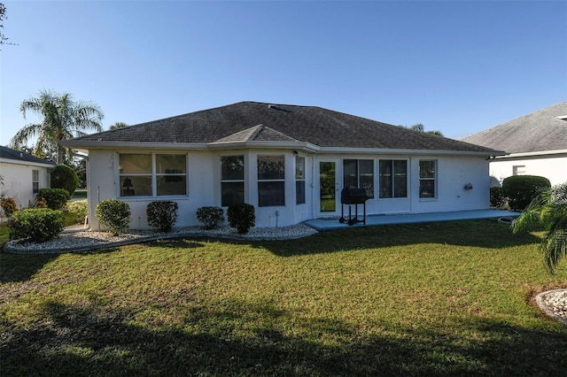 2451 E Del Webb Blvd, Sun City Center, FL 33573 - back of house featuring a shingled roof, a lawn, a patio, and stucco siding