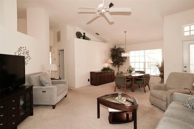 living room featuring light colored carpet, ceiling fan with notable chandelier, high vaulted ceiling, and a healthy amount of sunlight