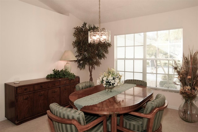 dining space featuring vaulted ceiling, light colored carpet, and a notable chandelier