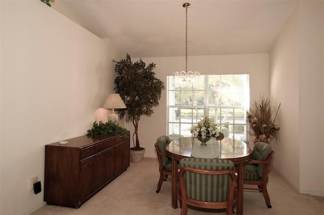 carpeted dining space featuring a notable chandelier