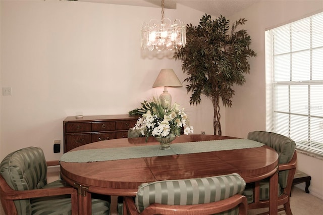 carpeted dining space featuring a chandelier