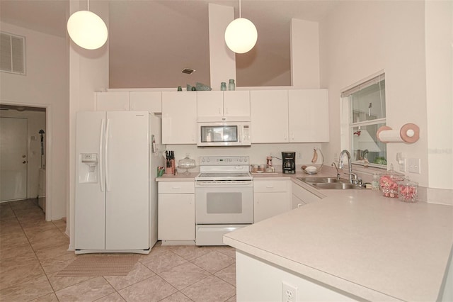 kitchen with white cabinets, hanging light fixtures, a high ceiling, and white appliances